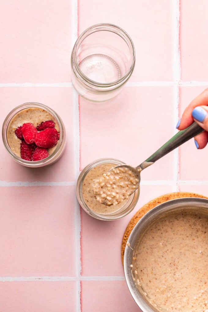 hand spooning overnight oats into mason jars