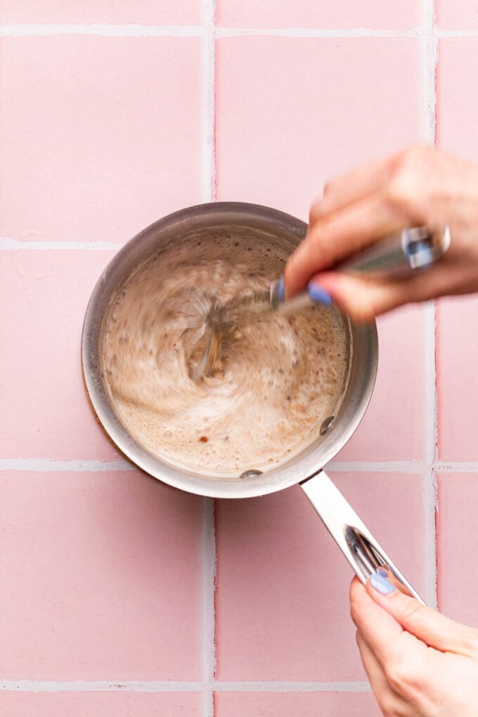 hand whisking pot of oats