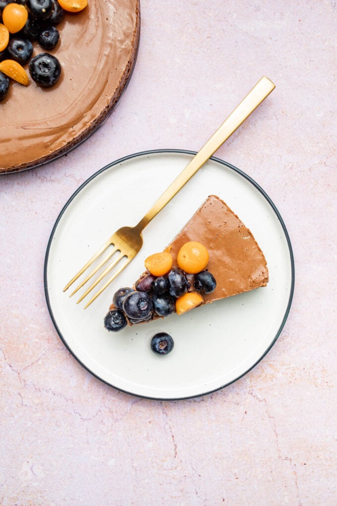 vegan chocolate mousse cake sliced on white plate with spoon